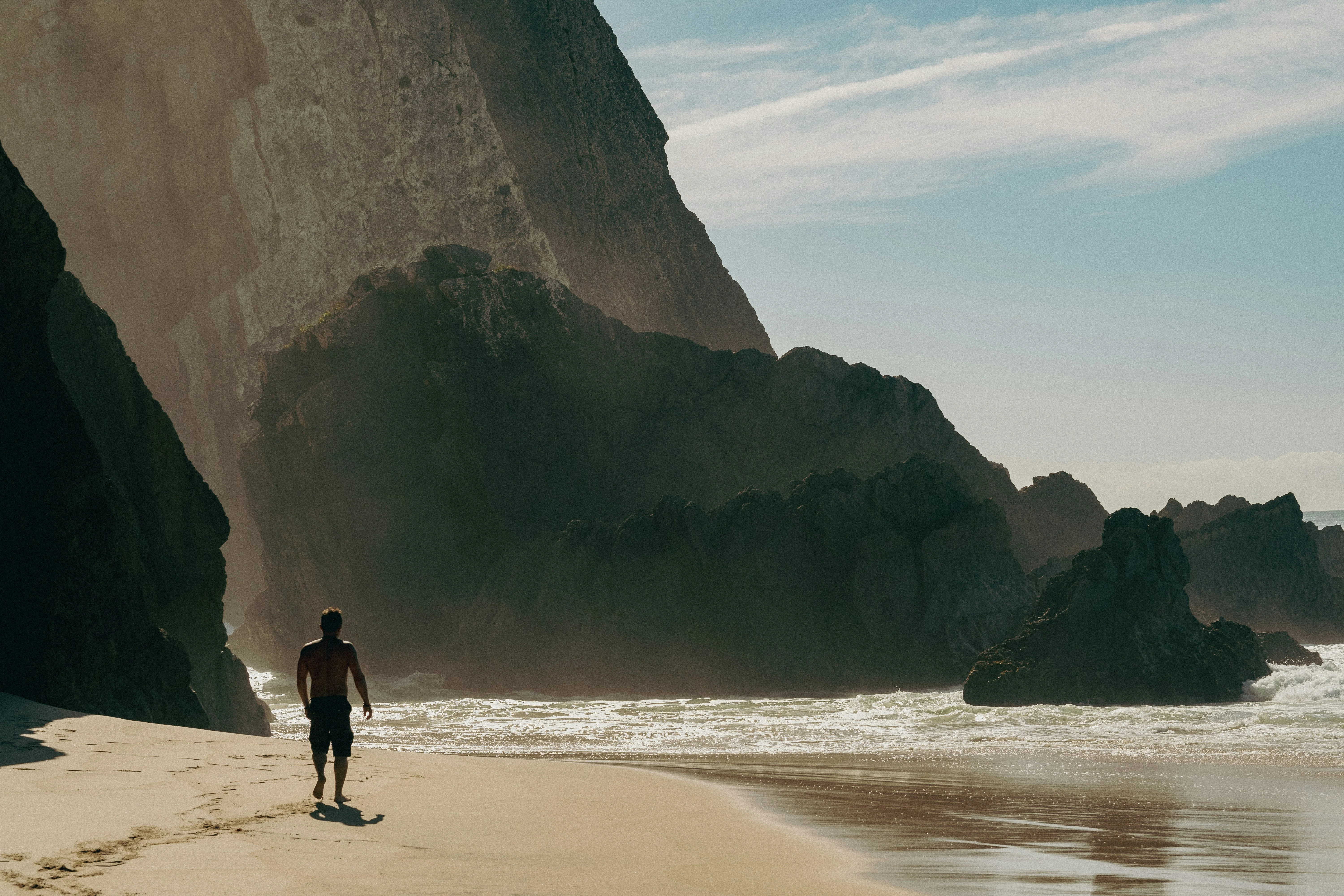 Dramatic beach with towering cliffs and ocean waves