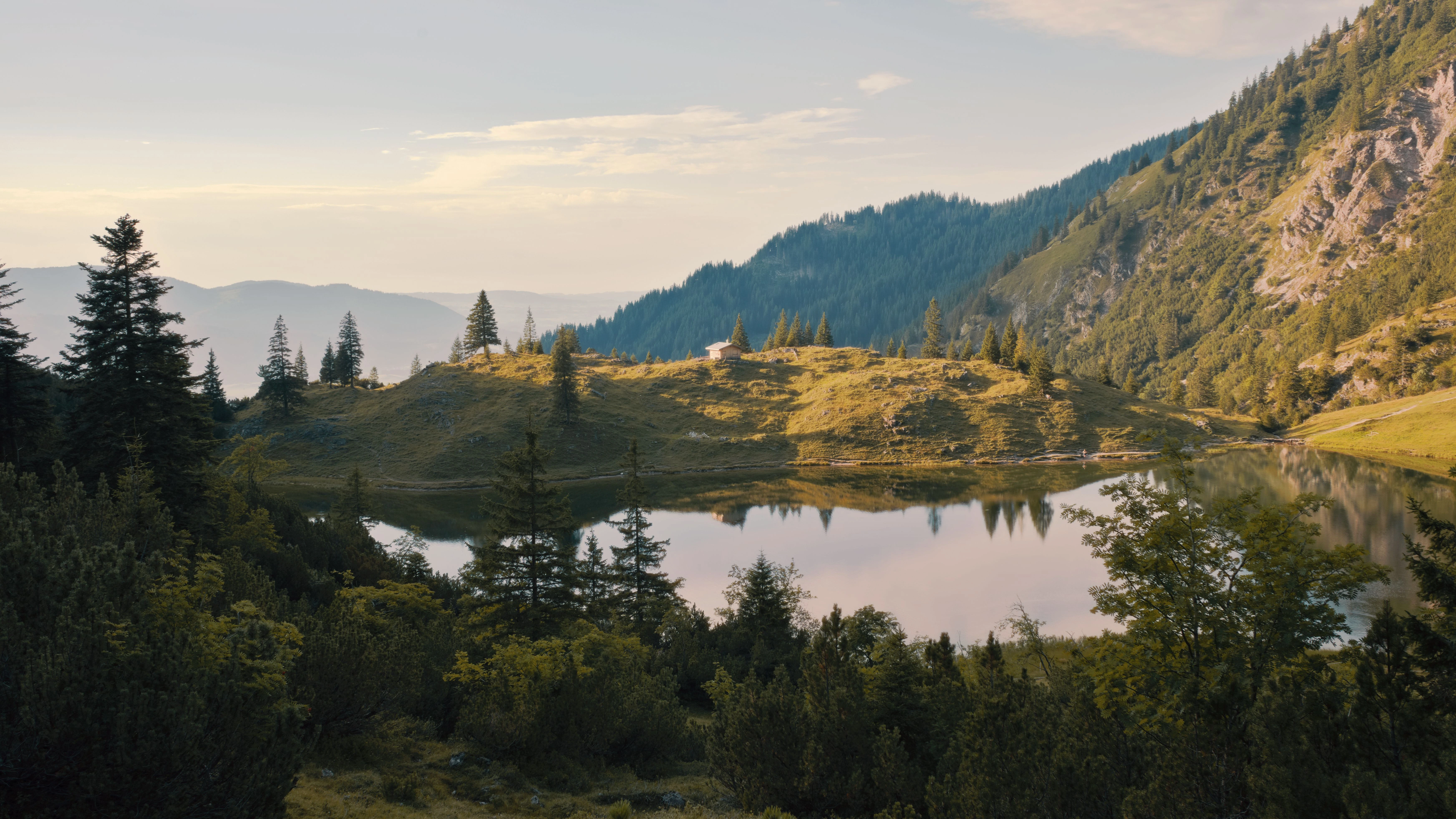 Mountain lake surrounded by pine forests at sunset